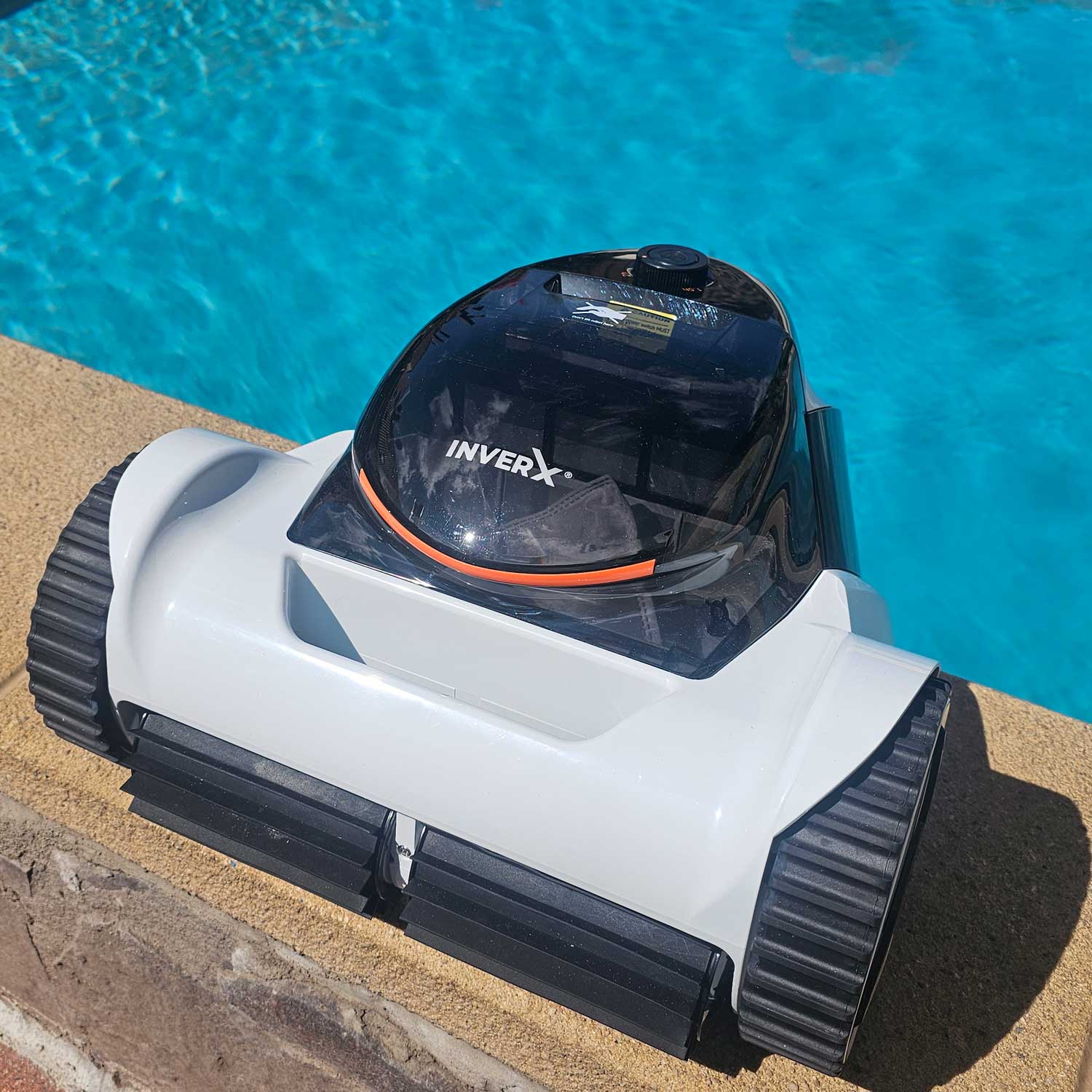 Automatischer Poolreiniger, der in der Nähe eines Schwimmbeckenrandes positioniert ist.