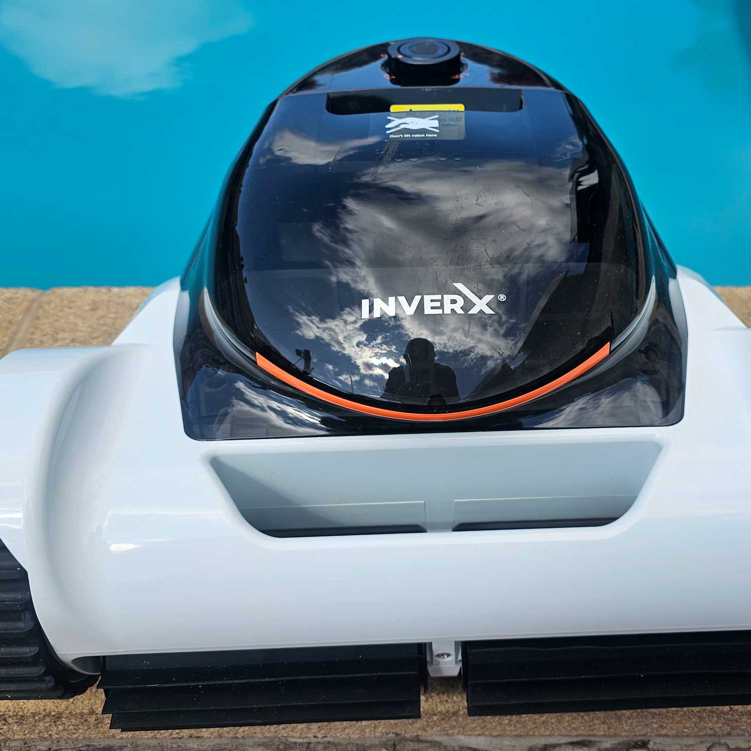 Roboter-Poolreiniger in der Nähe eines Schwimmbadrandes positioniert.