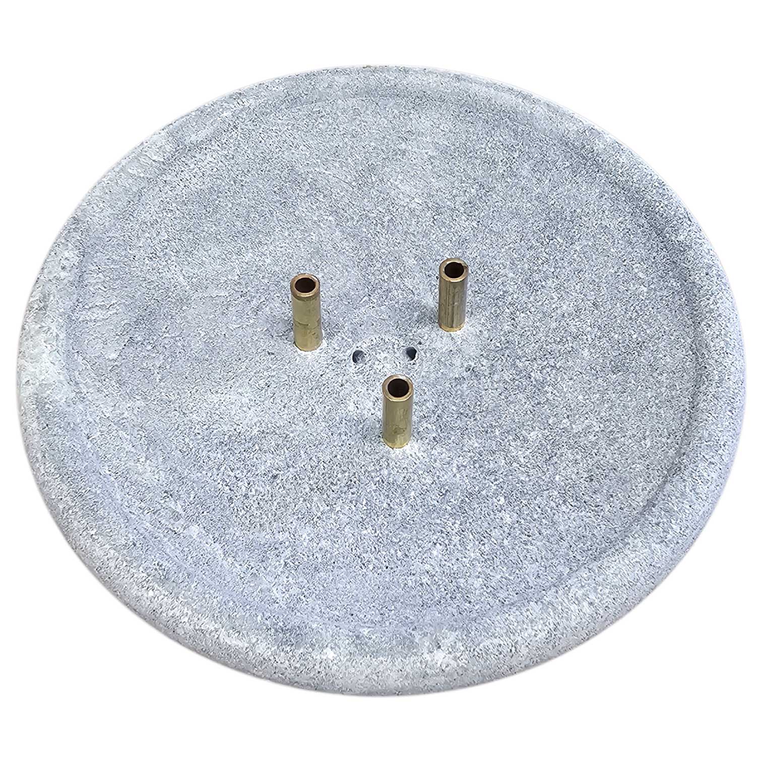 Runder Brunnensockel aus grauem Stein mit drei Messingausläufen und zentralen Abflusslöchern.