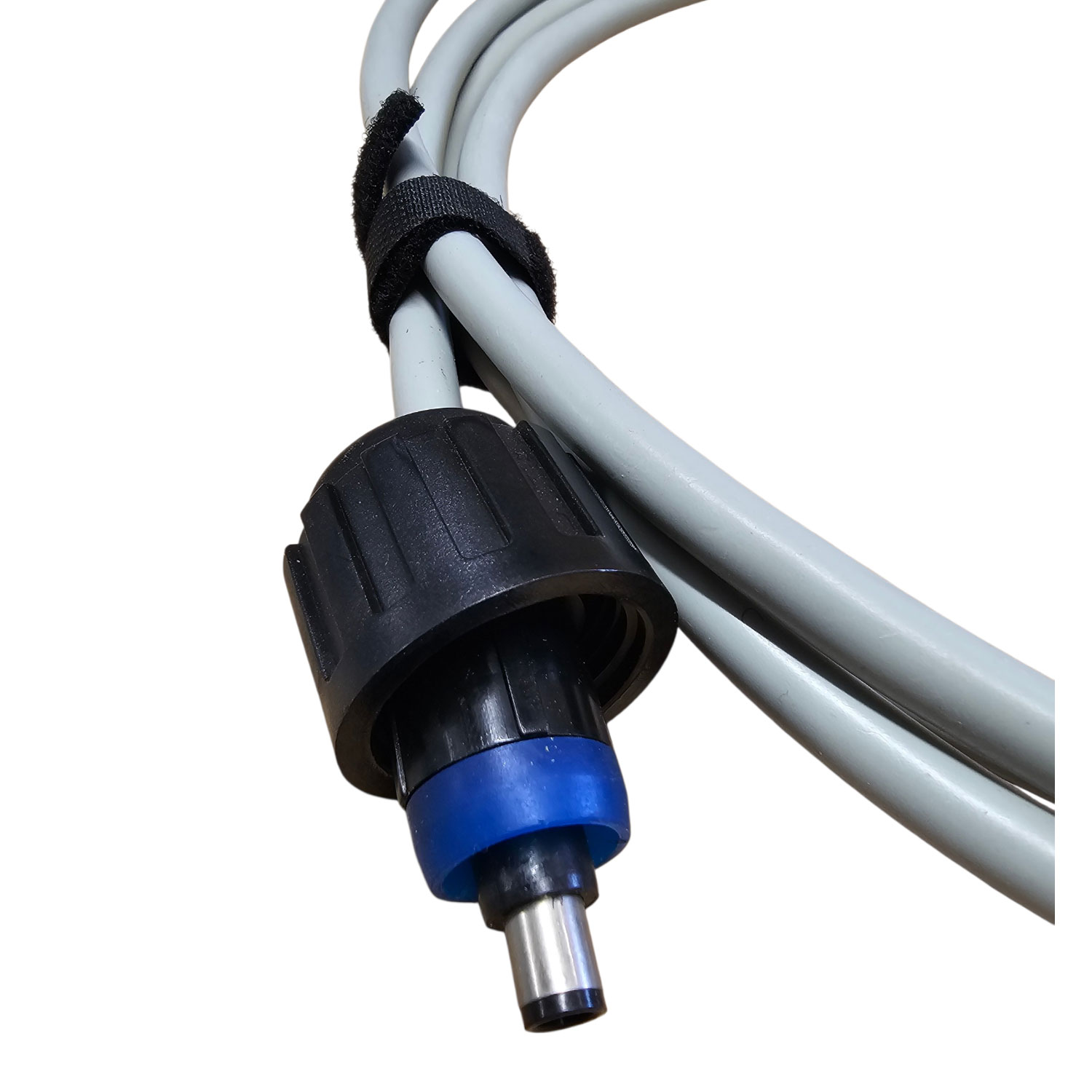 Nahaufnahme eines schwarzen und blauen Anschlusses, der an graue Schläuche angeschlossen ist.