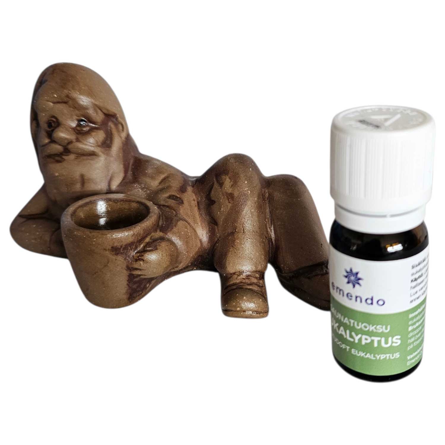Eine Keramikzwergfigur mit einer kleinen Tasse neben einer Flasche ätherischem Eukalyptusöl.