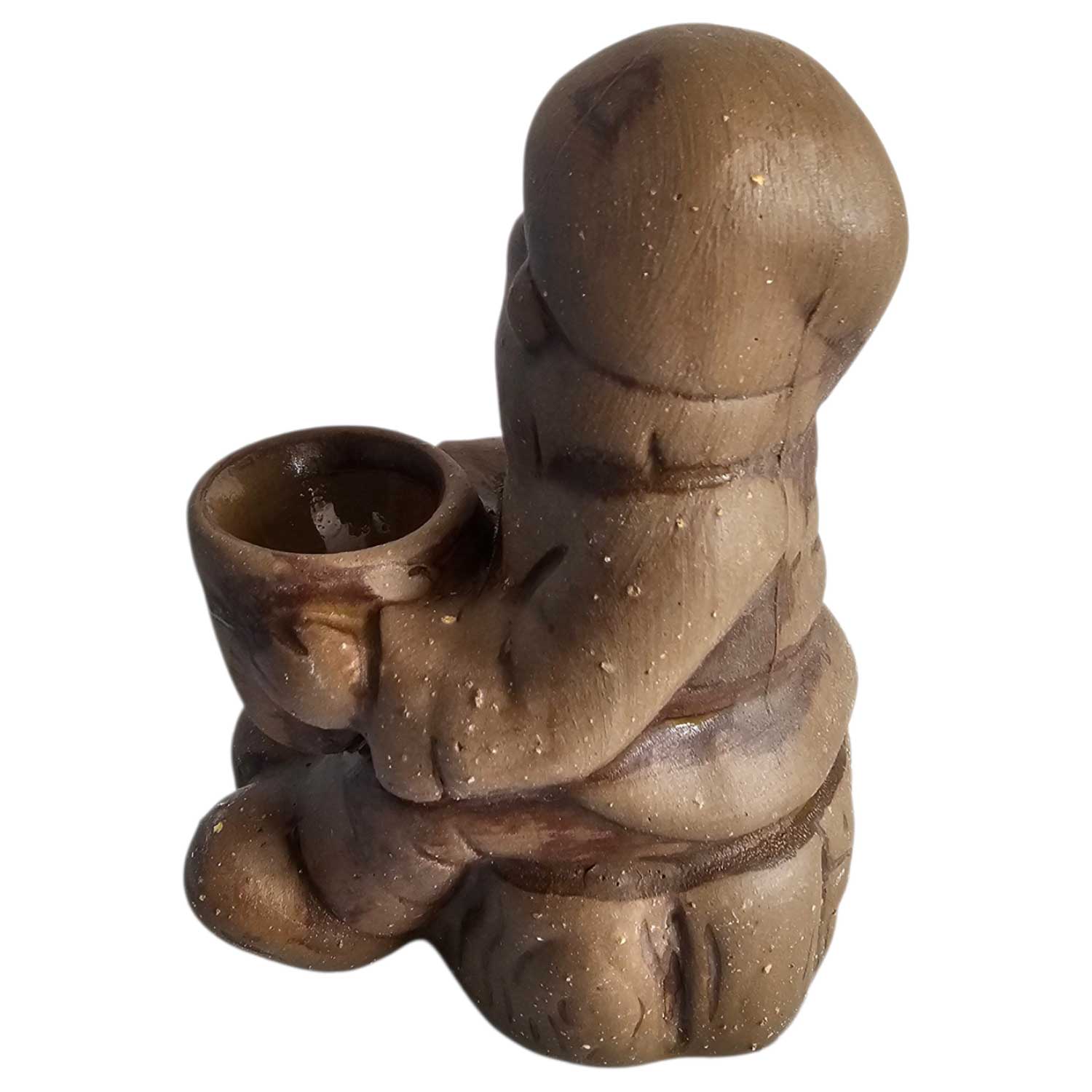 Eine braune Keramikfigur einer Person, die sitzt und einen kleinen schalenförmigen Behälter hält.