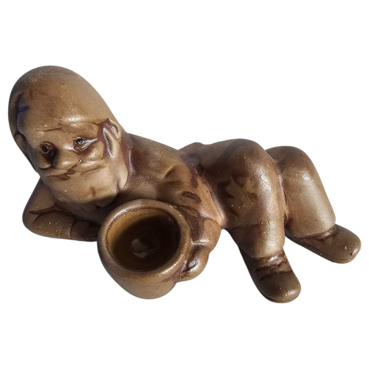 Eine braune Keramikfigur eines liegenden Gnoms, der eine kleine Schüssel hält.
